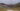 Shepherds huts and small lake with mineral rich mountains.